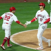 Shohei Ohtani (right) is congratulated by Angels teammate David Fletcher after hitting a two-run home run against the Rays on Monday in Anaheim, California. | USA TODAY / VIA REUTERS