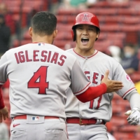 The Angels' Shohei Ohtani celebrates with teammate Jose Iglesias after giving his team the lead with a two-run home run against the Red Sox in the ninth inning in Boston on Sunday. | KYODO