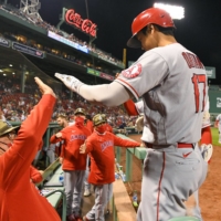 Los Angeles Angels designated hitter Shohei Ohtani high-fives manager Joe Maddon after hitting a solo home run against the Boston Red Sox during the sixth inning at Fenway Park on Friday. | USA TODAY SPORTS / VIA REUTERS