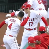 Shohei Ohtani celebrates with Angels teammate Jose Iglesias after hitting his league-leading 14th home run on Tuesday in Anaheim, California. | KYODO