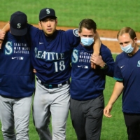 Mariners pitcher Yusei Kikuchi (second from left) is helped off the field after being hit by a ball during his start against the Angels on Saturday in Anaheim, California. | JUN 5, 2021; ANAHEIM, CALIFORNIA, USA; SEATTLE MARINERS STARTING PITCHER YUSEI KIKUCHI (18) IS HELPED OFF THE FIELD AFTER BEING HIT BY A BALL FROM LOS ANGELES ANGELS SECOND BASEMAN DAVID FLETCHER (22) DURING THE FIFTH INNING AT ANGEL STADIUM. MANDATORY CREDIT: GARY A. VASQUEZ-USA TODAY SPORTS