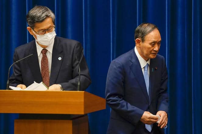 Le premier ministre japonais Yoshihide Suga, à droite, derrière le président du comité consultatif gouvernemental sur la pandémie, Shigeru Omi, le 17 août 2021, à Tokyo.