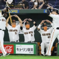 Giants players welcome Yoshihiro Maru (right) back to the dugout after his first-inning home run on Saturday at Tokyo Dome. | KYODO