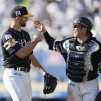 Hawks pitcher Nick Martinez (left) and catcher Takuya Kai return to the dugout after the fourth inning in Chiba on Thursday. | KYODO