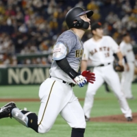 Hanshin's Kento Itohara begins to round the bases after hitting a solo home run against the Giants' Tomoyuki Sugano at Tokyo Dome on Saturday. | KYODO