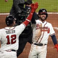 Braves shortstop Dansby Swanson (right) celebrates a home run against the Astros with designated hitter Jorge Soler during the seventh inning of Game 4 of the World Series on Saturday in Atlanta. | USA TODAY / VIA REUTERS
