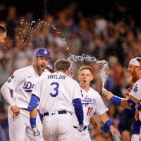 The Dodgers celebrate at home plate after Chris Taylor's game-winning home run against the Cardinals in Los Angeles on Wednesday. | USA TODAY / VIA REUTERS