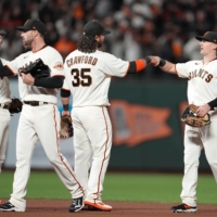 San Francisco Giants right fielder Mike Yastrzemski (5) and shortstop Brandon Crawford (35) celebrate with teammates after defeating the Los Angeles Dodgers in Game One of the NLDS on Friday. | USA TODAY / VIA REUTERS