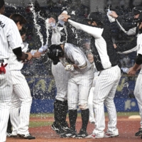 Lotte players celebrate Takashi Ogino's walk-off single to beat the Fighters on Saturday in Chiba. | KYODO