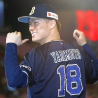 Orix pitcher Yoshinobu Yamamoto points to his No. 18 after recording his 18th win of the season over Rakuten on Monday in Sendai. | KYODO