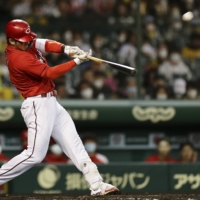 Carp outfielder Seiya Suzuki hits his 38th home run of the season against the Tigers on Sunday in Nishinomiya, Hyogo Prefecture. | KYODO