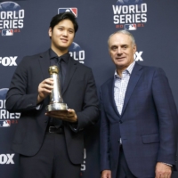 Shohei Ohtani (left) poses with MLB Commissioner Rob Manfred after receiving the Commissioner's Historic Achievement Award on Tuesday in Houston. | KYODO
