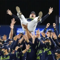 The Swallows toss manager Shingo Takatsu into the air after clinching the Central League title at Yokohama Stadium on Tuesday. | KYODO