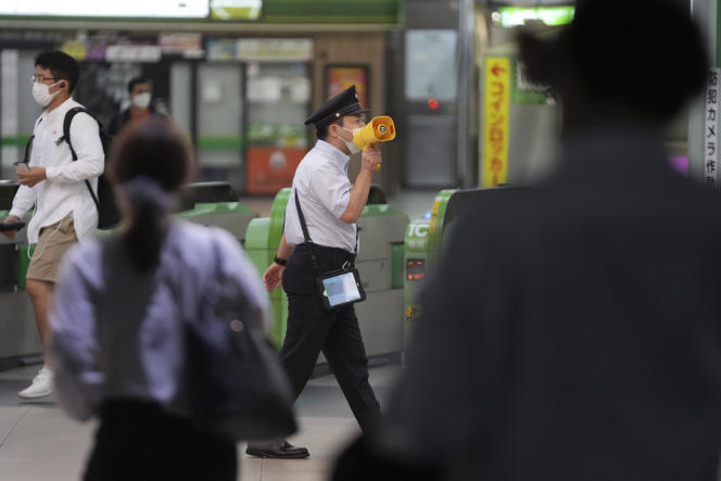 Un agent de la station Shinjuku, à Tokyo, annonce la reprise du service après le séisme survenu dans la capitale japonaise, le 7 octobre 2021.