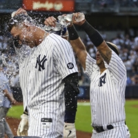 Yankees right fielder Aaron Judge is doused with water after a hitting a walk-off single against the Rays to clinch a wild card spot in New York on Sunday. | USA TODAY / VIA REUTERS