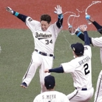 The Buffaloes' Masataka Yoshida (left) celebrates with his teammates after his walk-off double in the ninth against the Swallows in Game 1 of the Japan Series in Osaka on Saturday. | KYODO