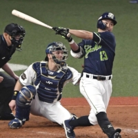 The Swallows' Norichika Aoki connects on an RBI single against the Buffaloes during the eighth inning in Game 2 of the Japan Series at Kyocera Dome Osaka on Sunday. | KYODO