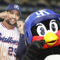The Swallows' Domingo Santana poses for photos with mascot Tsubakuro after Game 3 of the Japan Series at Tokyo Dome on Tuesday. | KYODO
