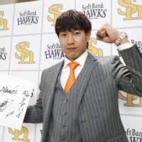 Hawks outfielder Yuki Yanagita poses for photos following a news conference in Fukuoka on Friday. | KYODO