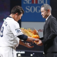 Ichiro Suzuki (right) presents retiring Lions pitcher Daisuke Matsuzaka with a bouquet at MetLife Field in Tokorozawa, Saitama Prefecture, on Saturday. | KYODO