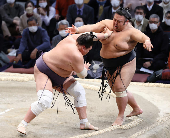 Le lutteur Terunofuji Haruo (à gauche) vainqueur de Takakeishō Mitsunobu, lors du tournoi de sumo Kyushu basho, à Fukuoka, le 28 novembre 2021.