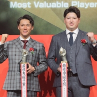 Pacific League MVP Yoshinobu Yamamoto (left) and Central League MVP Munetaka Murakami pose for photos during the NPB Awards on Wednesday. | KYODO