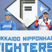 Fighters manager Tsuyoshi Shinjo (right) and pitcher Naoyuki Uwasawa speak during a news conference in Sapporo on Friday. | KYODO