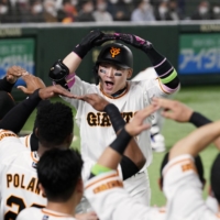 Giants outfielder Yoshihiro Maru celebrates after hitting a solo home run against the Dragons during the second inning at Tokyo Dome on Friday night. | KYODO