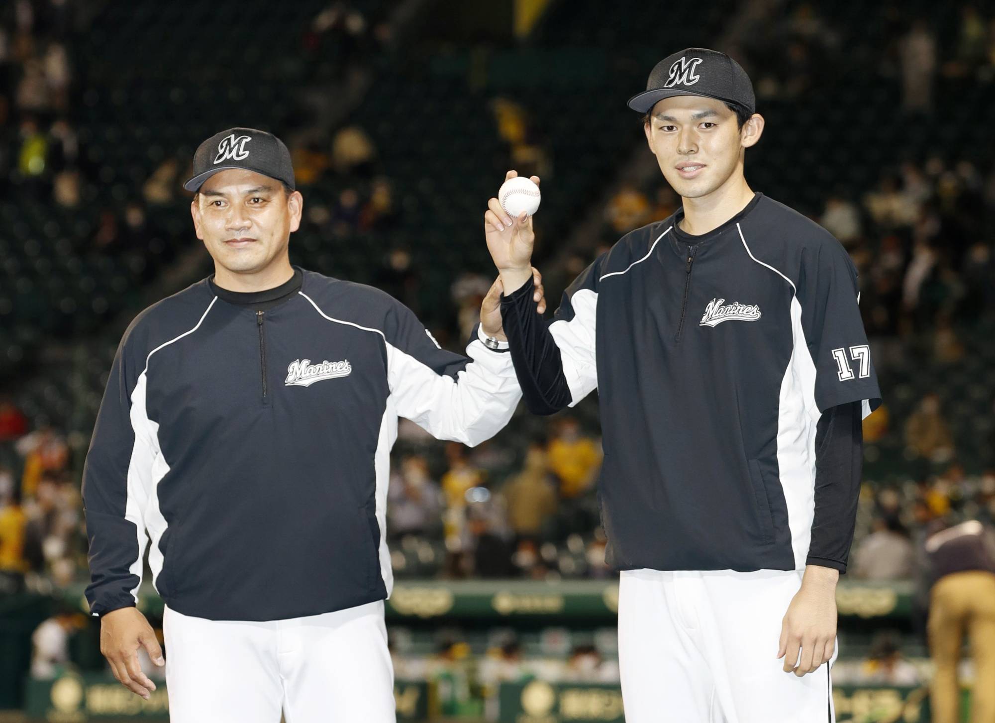 Roki Sasaki (right) celebrates his first win with Lotte manager Tadahito Iguchi against the Tigers in Nishinomiya, Hyogo Prefecture, in May 2015. | KYODO