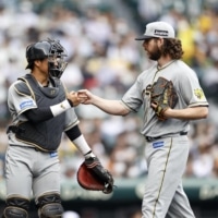 Tigers pitcher Aaron Wilkerson fist-bumps catcher Kenya Nagasaka after the fifth inning of their game against the Giants in Nishinomiya, Hyogo Prefecture, on Saturday. | KYODO
