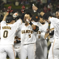 Hiroyuki Nakajima (center) celebrates with his Yomiuri teammates after their come-from-behind win over the Carp in Utsunomiya on Tuesday. | KYODO