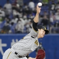 The Tigers' Junya Nishi pitches against the Swallows at Jingu Stadium on Wednesday. | KYODO