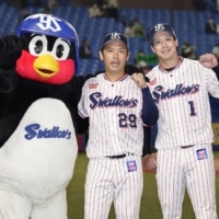 The Swallows' Tetsuto Yamada (right) and Yasuhiro Ogawa pose with the team mascot after their win over the Tigers on Thursday at Jingu Stadium. | KYODO