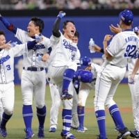 The Dragons celebrate Taiki Mitsumata's walk-off single against the Swallows in Nagoya on Tuesday. | KYODO