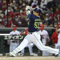 The Swallows' Munetaka Murakami hits a two-run home run against the Carp during the ninth inning in Hiroshima on Wednesday. | KYODO