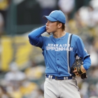 Fighters starter Kosei Yoshida reacts after allowing a three-run home run against the Tigers' Yusuke Oyama at Koshien Stadium on Sunday. | KYODO