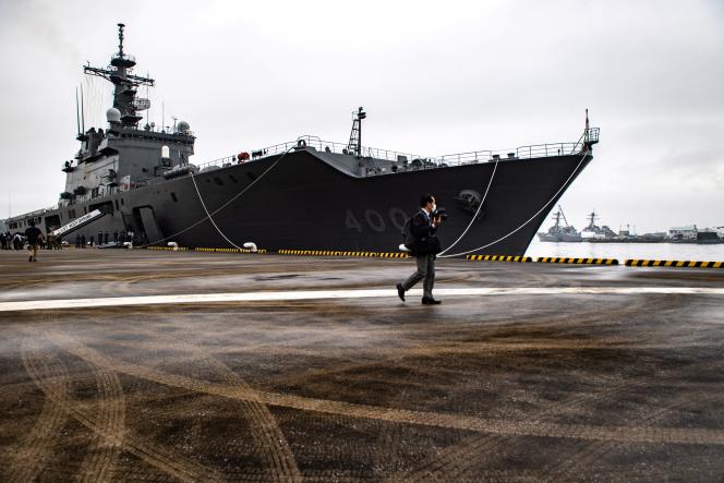Un journaliste passe devant un navire de la Force maritime d’autodéfense du Japon, sur la base navale de Yokosuka, (préfecture de Kanagawa) au sud de Tokyo, le 16 juin 2022.