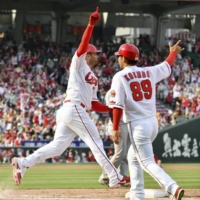 Carp first-baseman Ryan McBroom (left) celebrates after his walk-off two-run home run against the Giants in Hiroshima on Saturday. | KYODO