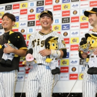 Tigers players (from left) Yuki Nishi, Fumiya Hojo and Yasuhiro Yamamoto participate in the hero interview following the team's win over the Carp at Koshien Stadium on Wednesday. | KYODO