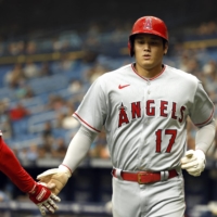 Shohei Ohtani is congratulated after scoring a run during the Angels' loss to the Rays in St. Petersburg, Florida, on Thursday. | USA TODAY / VIA REUTERS