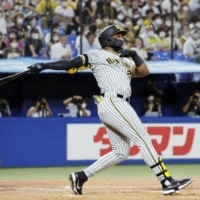 The Tigers' Mel Rojas Jr. connects on a three-run home run against the Swallows at Jingu Stadium on Thursday. | KYODO