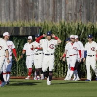 The Cubs and Reds emerge from the cornfields prior to the start of their game at the Field of Dreams in Dyersville, Iowa, on Thursday. | KYODO