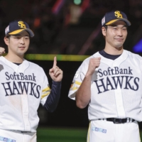 SoftBank Hawks infielder Hikaru Kawase (left) and pitcher Shota Takeda celebrate after the team's 9-1 win on Saturday. | KYODO