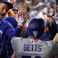 Dodgers second baseman Mookie Betts high-fives his teammates after hitting a home run against the Diamondbacks in Phoenix on Monday. | USA TODAY / VIA REUTERS