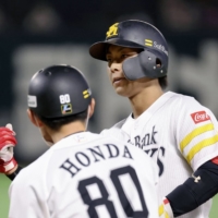 SoftBank's Kenta Imamiya (right) celebrates after driving in two runs against the Lions in Fukuoka on Monday. | KYODO