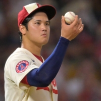 Angels pitcher Shohei Ohtani checks the ball during a game against the Astros in Anaheim, California, on Saturday. | USA TODAY / VIA REUTERS