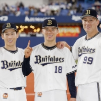 Buffaloes pitcher Yoshinobu Yamamoto (center) celebrates with teammates Masataka Yoshida (left) and Yutaro Sugimoto after Game 1 of the Pacific League Climax Series Final Stage in Osaka on Wednesday. | KYODO