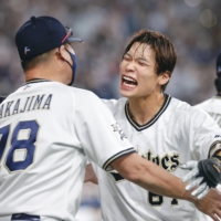 Buffaloes' Keita Nakagawa (center) celebrates after hitting a walk-off single in Game 4 of the Pacific League Climax Series against the SoftBank Hawks at Kyocera Dome in Osaka on Saturday. | KYODO
