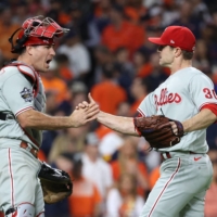 Philadelphia Phillies relief pitcher David Robertson (right) and catcher J.T. Realmuto celebrate on the field after defeating the Houston Astros in Game 1 of the World Series on Friday in Houston. | USA TODAY / VIA REUTERS