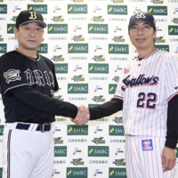 Buffaloes manager Satoshi Nakajima (left) and Swallows manager Shingo Takatsu shake hands after a news conference in Tokyo on Friday, the day before Game 1 of the Japan Series. | KYODO